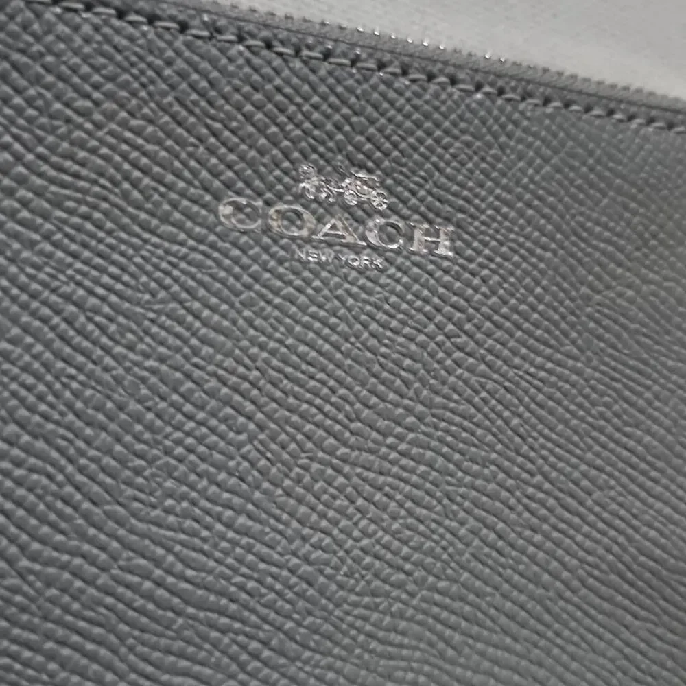 Coach Corner Zip Wristlet in a grey crossgrain leather.